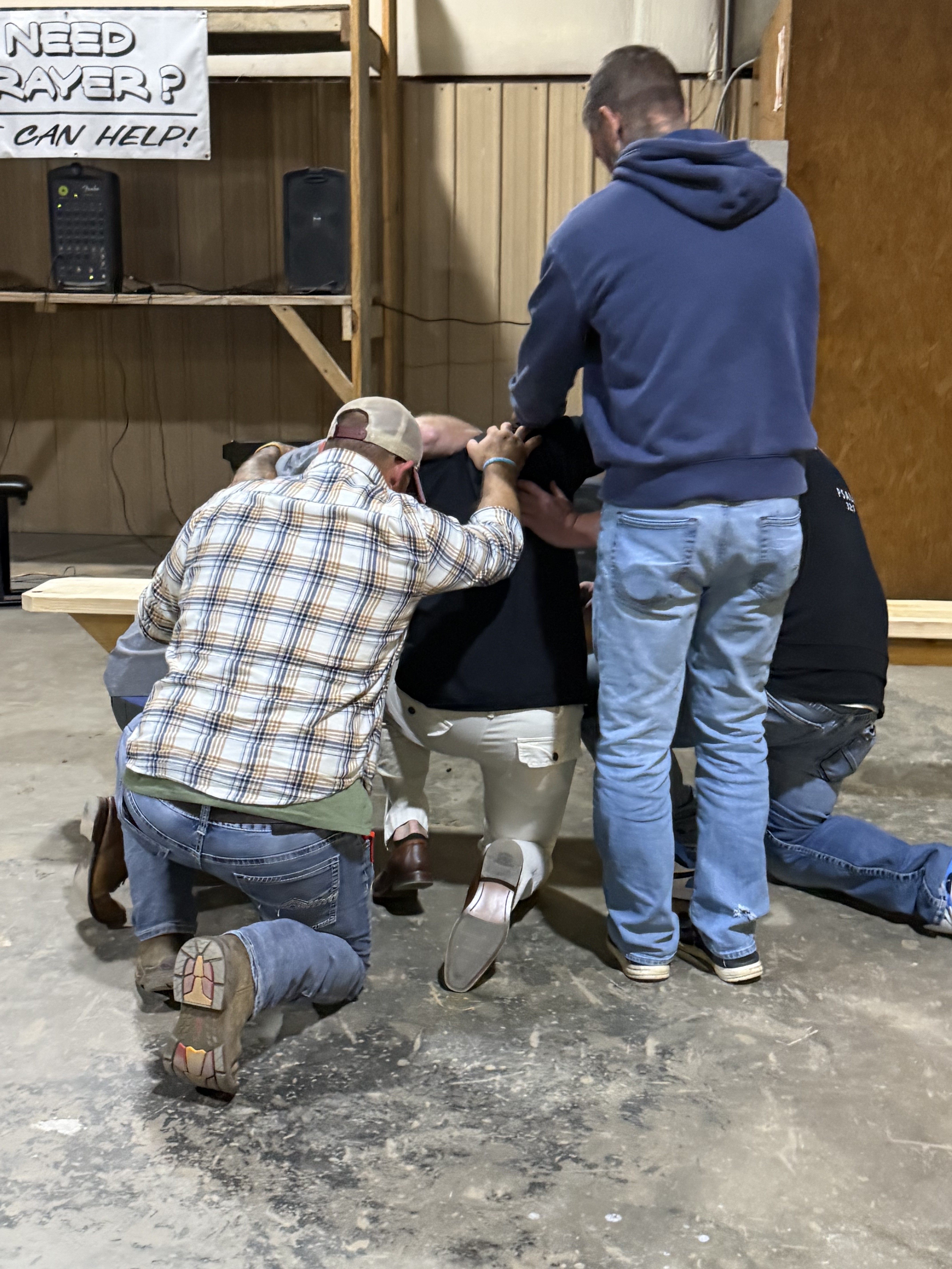 Men kneeling in prayer at the altar