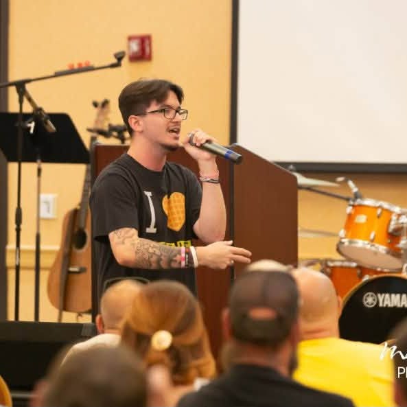 Sharing a testimony from the front of the room